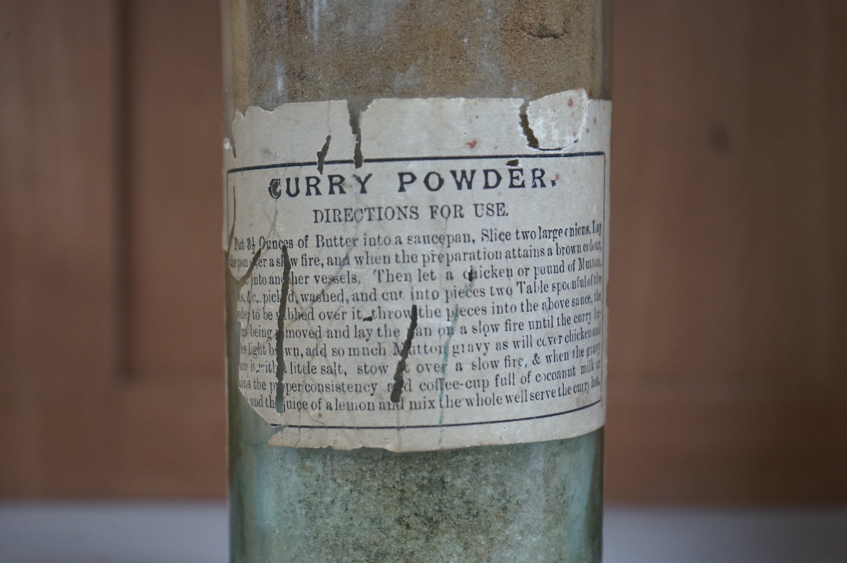 A 19th century sealed bottle of Indian curry powder, with original labels, 28cm high
